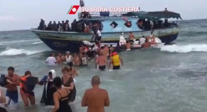 Le identità collettive del sentire umano universale In una spiaggia nei pressi di Siracusa, i bagnanti prestano soccorso agli immigrati africani