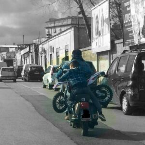 Scene di ordinaria inciviltà a Napoli, dove in periferia un bimbo a bordo di uno scooter tiene in braccio una mini moto.