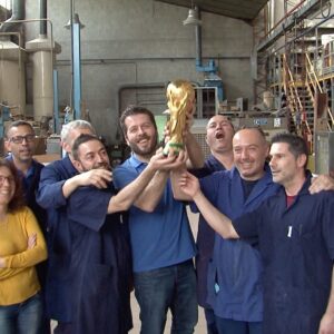 Operai della Bertoni GDE sollevano la copia dorata della Coppa del mondo