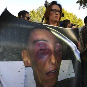 Ilaria Cucchi, sorella di Stefano, mostra l'immagine del fratello massacrato mentre era in stato di detenzione